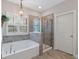 Bright, stylish bathroom features a soaking tub, glass-enclosed shower, and elegant fixtures at 4814 Little Cove Ct, Auburn, GA 30011