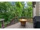 View of the deck with a wine barrel fire pit, a grill, and a wooded backyard at 4814 Little Cove Ct, Auburn, GA 30011