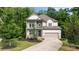 Inviting two-story home with a manicured lawn, attached garage, and charming balcony at 4814 Little Cove Ct, Auburn, GA 30011