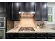 Kitchen stovetop with modern range hood, stainless appliances, and dark wood cabinets at 4814 Little Cove Ct, Auburn, GA 30011