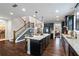Open kitchen layout with a large island, stainless appliances, and wood staircase at 4814 Little Cove Ct, Auburn, GA 30011
