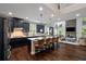 Open-concept kitchen featuring dark cabinets, a large island, granite countertops, and stainless steel appliances at 4814 Little Cove Ct, Auburn, GA 30011