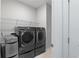 Modern laundry room featuring front-load washer and dryer with folding table, with wire shelving at 4814 Little Cove Ct, Auburn, GA 30011