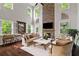 Bright living room featuring a stone fireplace, tall windows, and hardwood floors at 4814 Little Cove Ct, Auburn, GA 30011