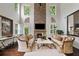 Elegant living room with a stone fireplace, tall windows, and hardwood floors at 4814 Little Cove Ct, Auburn, GA 30011