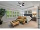 Bright main bedroom featuring tray ceiling, large windows, and cozy seating area at 4814 Little Cove Ct, Auburn, GA 30011