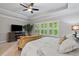 Main bedroom featuring trey ceiling, large windows, and an entertainment center at 4814 Little Cove Ct, Auburn, GA 30011