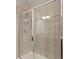 Modern shower with tile surround, a glass door, and built-in shelving for added convenience at 4814 Little Cove Ct, Auburn, GA 30011