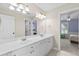 Bathroom with double vanity, large mirrors, and a view into the bedroom at 5054 Kingsbridge Pass, Powder Springs, GA 30127