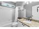 Bathroom with white tile, granite countertop, modern fixtures, and a framed mirror at 5054 Kingsbridge Pass, Powder Springs, GA 30127