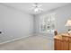 Neutral bedroom featuring carpet, plantation shutters, ceiling fan, and side table at 5054 Kingsbridge Pass, Powder Springs, GA 30127