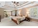 Comfortable bedroom featuring a tray ceiling, large windows and carpeted floors throughout at 5054 Kingsbridge Pass, Powder Springs, GA 30127