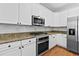 Modern kitchen featuring white cabinets, stainless steel appliances, and granite countertops at 5054 Kingsbridge Pass, Powder Springs, GA 30127