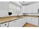 Bright kitchen with white cabinets, granite countertops, and a stainless-steel sink at 5054 Kingsbridge Pass, Powder Springs, GA 30127