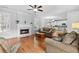 Inviting living room featuring hardwood floors, fireplace, ceiling fan, and view to the kitchen at 5054 Kingsbridge Pass, Powder Springs, GA 30127