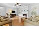 Cozy living room with a fireplace, hardwood floors, and large windows with plantation shutters at 5054 Kingsbridge Pass, Powder Springs, GA 30127