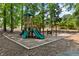 Community playground with slides and climbing structures surrounded by trees at 5054 Kingsbridge Pass, Powder Springs, GA 30127