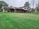 Green backyard with the back of the house and mature trees visible at 7437 Grayson Dr, Riverdale, GA 30296