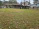 Large backyard with grass, scattered leaves, and partial view of the house at 7437 Grayson Dr, Riverdale, GA 30296