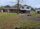 View of the home's backyard featuring a brick exterior, a sidewalk, and a few trees at 7437 Grayson Dr, Riverdale, GA 30296