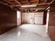 Unfinished basement featuring tile floor, exposed ceiling and access to the backyard at 7437 Grayson Dr, Riverdale, GA 30296