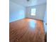 Spacious bedroom with hardwood floors and a window, offering natural light and a cozy atmosphere at 7437 Grayson Dr, Riverdale, GA 30296