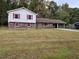 Exterior of charming split-level home with brick and siding, plus a large front lawn and carport at 7437 Grayson Dr, Riverdale, GA 30296