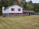 Split-level home with brick and siding, a large front yard, and a carport at 7437 Grayson Dr, Riverdale, GA 30296