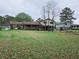 Property featuring spacious green yard, single story brick section, and two story section with large carport at 7437 Grayson Dr, Riverdale, GA 30296