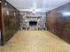 Living room featuring a stone fireplace, wood paneling, and a patterned floor at 7437 Grayson Dr, Riverdale, GA 30296