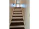 Carpeted staircase with white risers leading upstairs at 7437 Grayson Dr, Riverdale, GA 30296