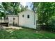 View of the home's exterior and backyard with a deck area among mature trees and lush green grass at 86 Kelly Ct, Dallas, GA 30157