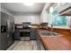 Modern kitchen features stainless steel appliances, wood countertops, and white subway tile backsplash at 86 Kelly Ct, Dallas, GA 30157