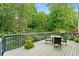 Enjoy a serene wooded view from this expansive deck with a table and seating at 1413 Eastbrooke Way, Marietta, GA 30066