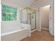 Elegant bathroom featuring a soaking tub with shower and a large window at 1413 Eastbrooke Way, Marietta, GA 30066