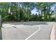 Community basketball court with hoops and benches surrounded by tall trees at 4211 Schooner Ne Ct, Roswell, GA 30075