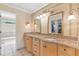 Bathroom featuring double sinks with granite counters, tiled walls, and a separate bathtub at 4211 Schooner Ne Ct, Roswell, GA 30075