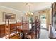 Formal dining room with wood furniture, chandelier, and large window with decorative curtains at 4211 Schooner Ne Ct, Roswell, GA 30075