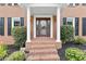 Close-up of the front porch with brick steps, white pillars and a stained wood front door at 4211 Schooner Ne Ct, Roswell, GA 30075