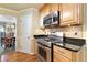 Kitchen area showcasing stainless steel stove and microwave, wood cabinetry, and granite countertops at 4211 Schooner Ne Ct, Roswell, GA 30075