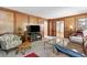 Living room with a fireplace, wood paneled wall, and vintage furniture at 4211 Schooner Ne Ct, Roswell, GA 30075