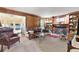 Cozy living room with hardwood floors, fireplace, wood paneling, and access to the sun room at 4211 Schooner Ne Ct, Roswell, GA 30075