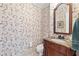 Powder room with patterned wallpaper, pedestal sink, and a decorative mirror at 4211 Schooner Ne Ct, Roswell, GA 30075