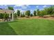 Expansive backyard showcasing lush green lawn, mature trees, and a covered patio at 515 Cobblestone Ct, Canton, GA 30115