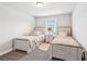 Charming bedroom featuring two twin beds with decoratively matching linens, a small window and an accent rug at 515 Cobblestone Ct, Canton, GA 30115