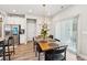 Well-lit dining area adjacent to kitchen featuring wood table, modern lighting, and stainless steel appliances at 515 Cobblestone Ct, Canton, GA 30115