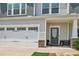 Charming home featuring a two-car garage, stylish front door with stone accents, and well-manicured landscaping at 515 Cobblestone Ct, Canton, GA 30115