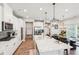 Modern kitchen with stainless steel appliances, white cabinets, quartz countertops, and an adjacent dining area at 515 Cobblestone Ct, Canton, GA 30115