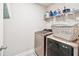 Functional laundry room with modern washer and dryer, and practical shelving at 515 Cobblestone Ct, Canton, GA 30115