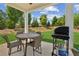 Inviting outdoor patio with dining table, chairs, and a grill, perfect for entertaining at 515 Cobblestone Ct, Canton, GA 30115